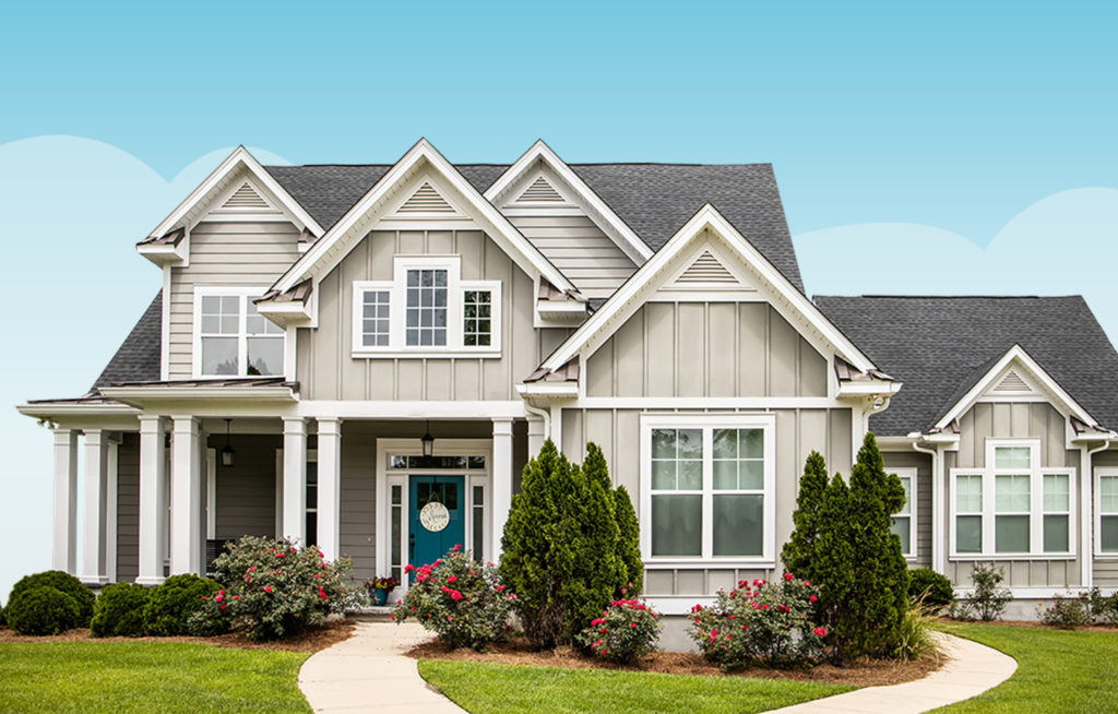 Large home and yard in front of sunny sky